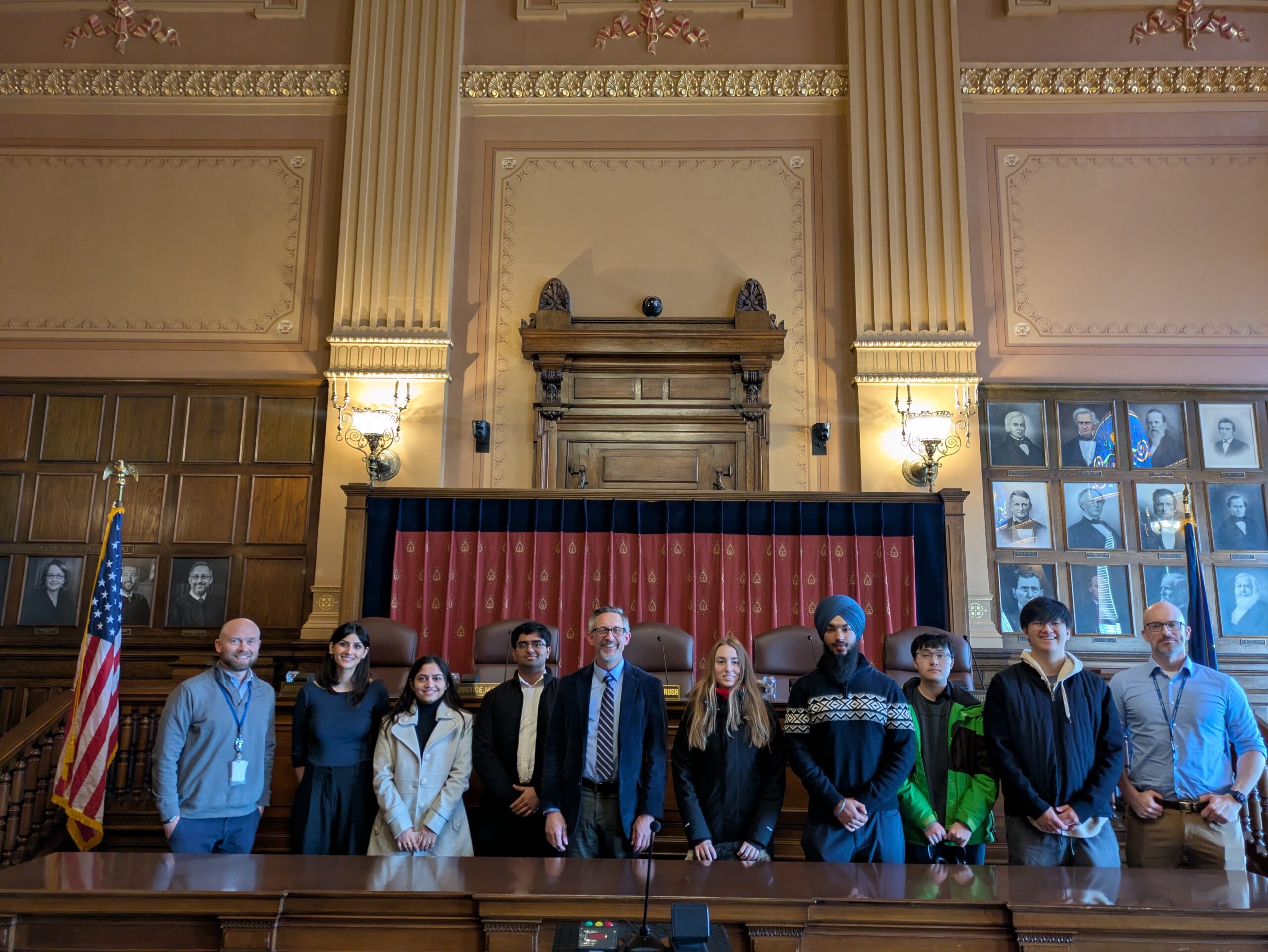 Students stand in front of a court room curtain.